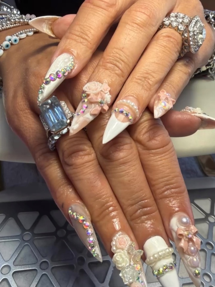 Long nude almond nails with white floral art and crystal details